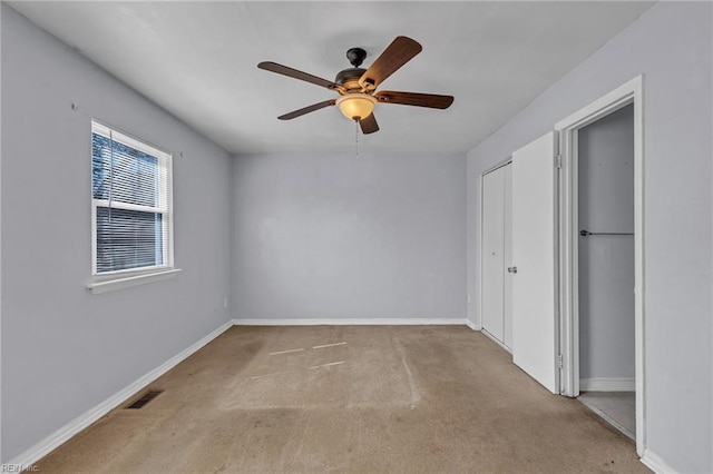 unfurnished bedroom with ceiling fan, carpet floors, visible vents, and baseboards