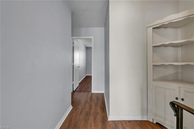 hallway featuring dark wood-style floors and baseboards