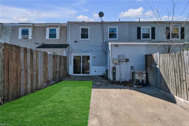 rear view of house featuring a lawn, fence private yard, and central air condition unit