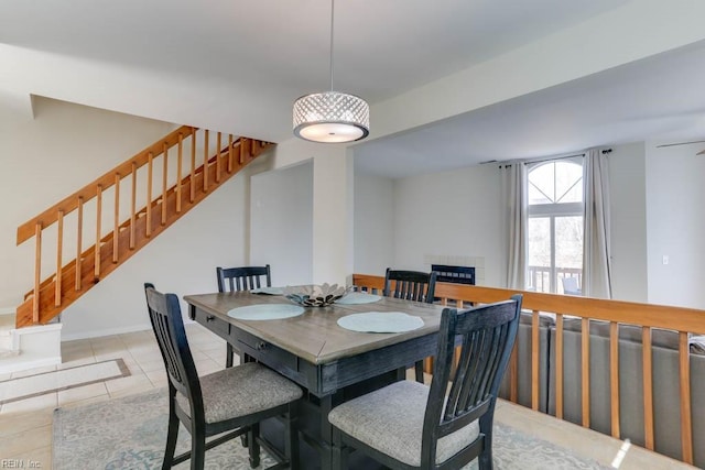 dining area featuring tile patterned flooring and stairway