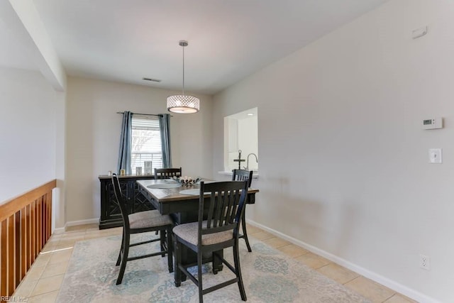 dining room featuring light tile patterned floors, visible vents, and baseboards