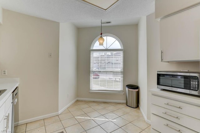 kitchen with light tile patterned floors, visible vents, appliances with stainless steel finishes, white cabinetry, and a textured ceiling