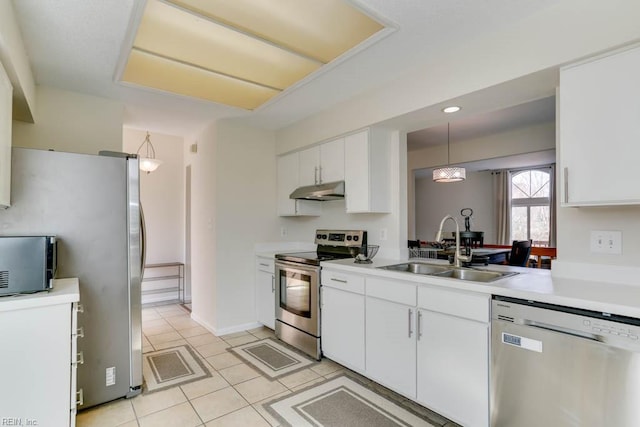 kitchen featuring under cabinet range hood, white cabinetry, appliances with stainless steel finishes, and a sink