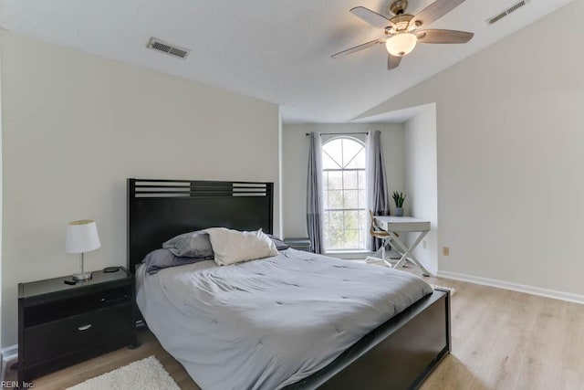 bedroom with lofted ceiling, light wood-style floors, baseboards, and visible vents