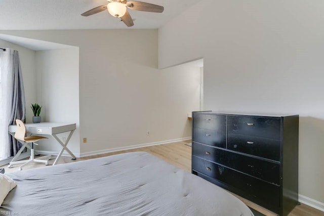 bedroom featuring ceiling fan, vaulted ceiling, baseboards, and wood finished floors