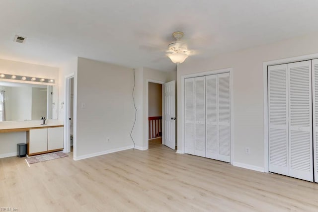 unfurnished bedroom with visible vents, baseboards, ceiling fan, light wood-type flooring, and multiple closets