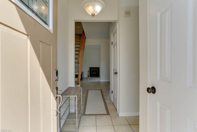 foyer entrance with light tile patterned floors and baseboards