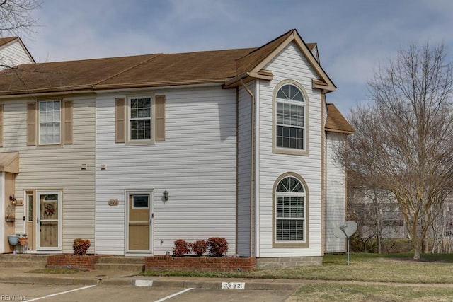 view of front of property with uncovered parking and roof with shingles