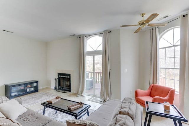 living room featuring tile patterned flooring, visible vents, and a tiled fireplace