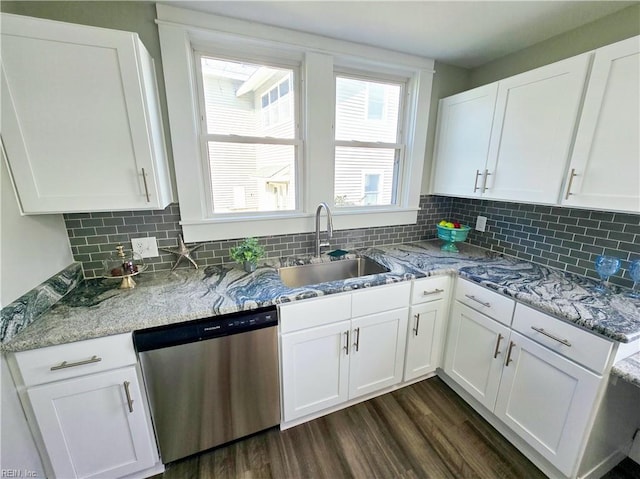 kitchen featuring decorative backsplash, white cabinets, dishwasher, dark wood-type flooring, and a sink