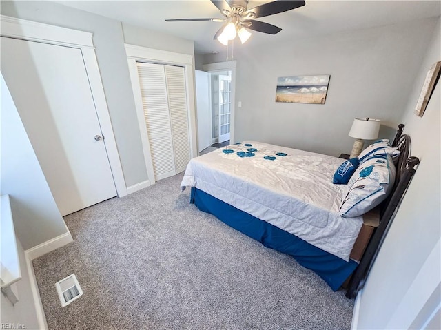 carpeted bedroom with baseboards, visible vents, and a ceiling fan