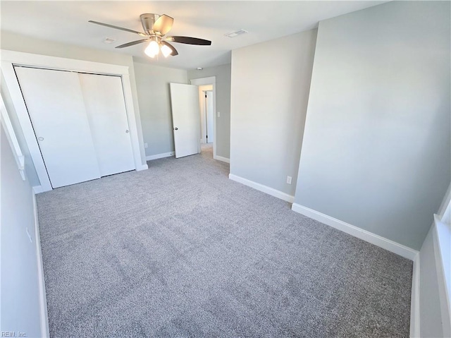 unfurnished bedroom featuring carpet floors, a closet, visible vents, ceiling fan, and baseboards