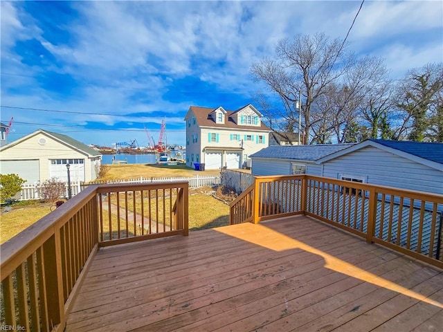 wooden deck featuring a water view, fence, and a yard