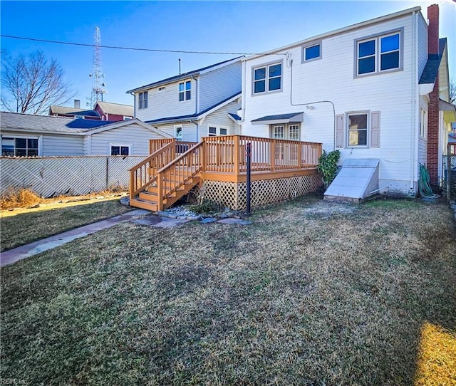 rear view of house featuring a yard, fence, and a wooden deck