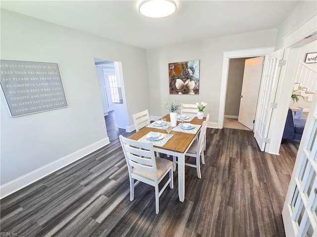 dining area featuring baseboards and dark wood-type flooring