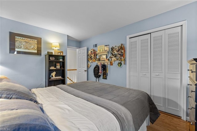 bedroom with a closet, visible vents, and wood finished floors