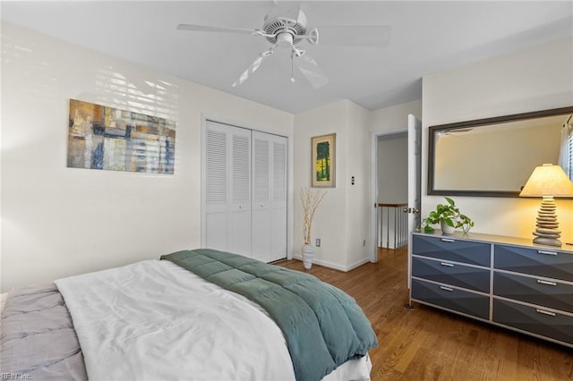 bedroom with baseboards, a closet, a ceiling fan, and wood finished floors