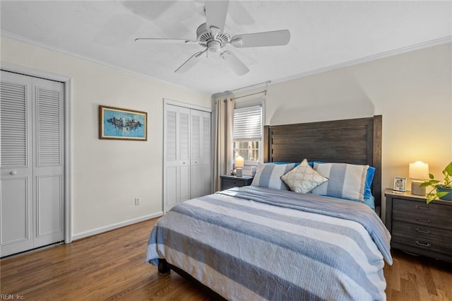 bedroom with multiple closets, ornamental molding, baseboards, and wood finished floors