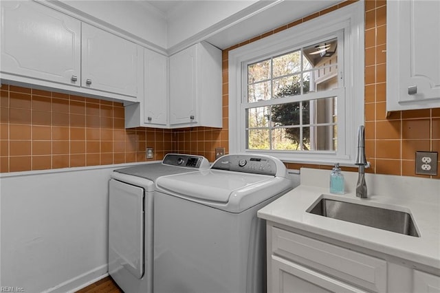 laundry room featuring cabinet space, a sink, and washing machine and clothes dryer