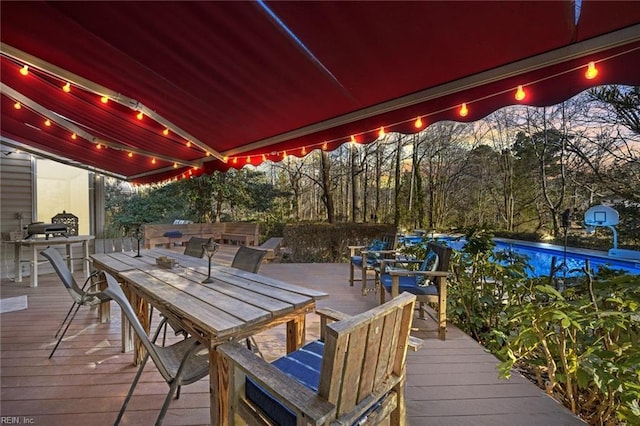 wooden terrace featuring a pool and outdoor dining space