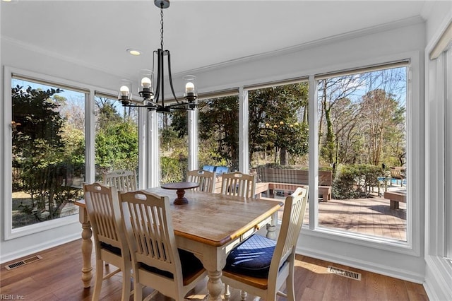 sunroom featuring visible vents and a notable chandelier