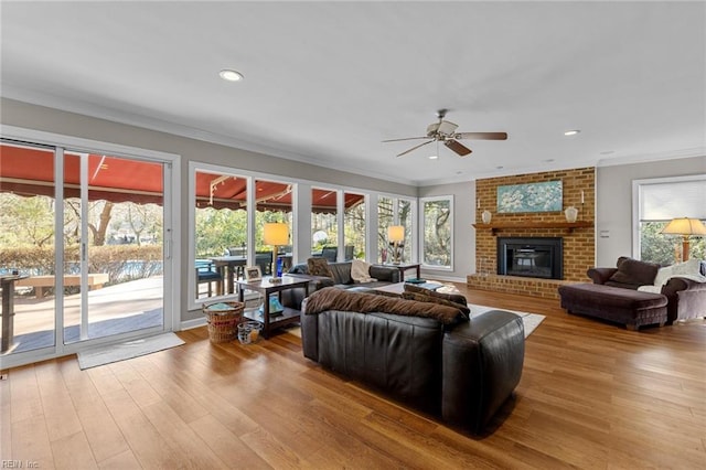 living area featuring a wealth of natural light, crown molding, and wood finished floors