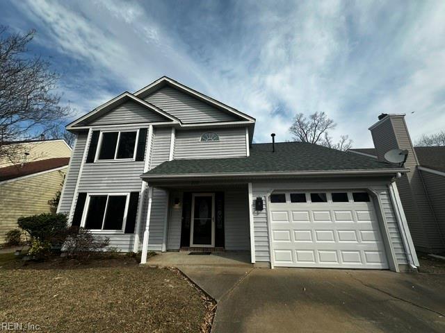 traditional home with concrete driveway, a chimney, and an attached garage