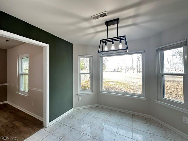 unfurnished dining area with visible vents and baseboards