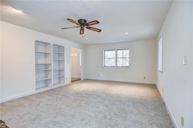 carpeted spare room featuring built in features, baseboards, a ceiling fan, and recessed lighting