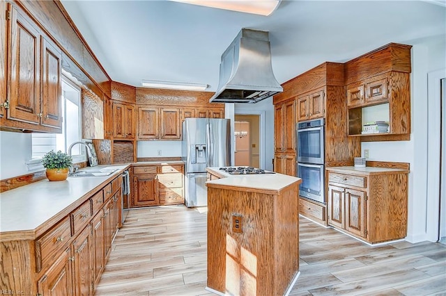 kitchen with a center island, brown cabinets, stainless steel appliances, wood tiled floor, and island range hood