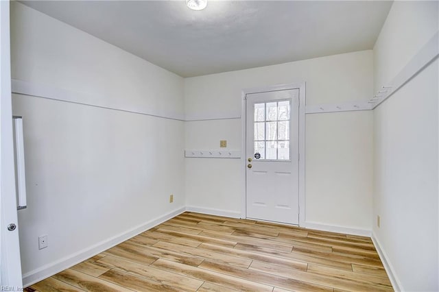 doorway to outside with light wood-type flooring and baseboards