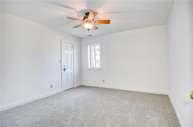 carpeted empty room with ceiling fan, visible vents, and baseboards