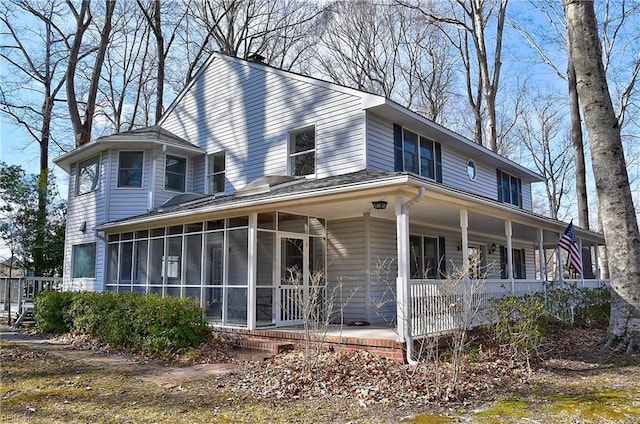 view of side of home with a sunroom and a porch