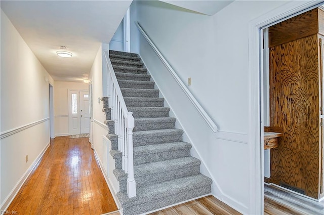 stairs with baseboards and hardwood / wood-style floors