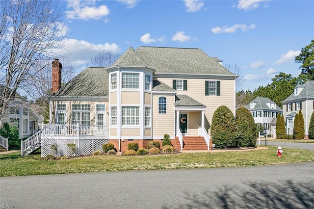 view of front of property with crawl space, a chimney, a front lawn, and roof with shingles