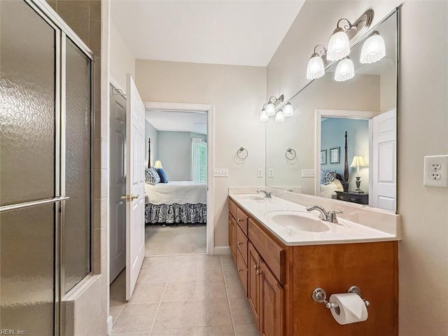 ensuite bathroom featuring a sink, connected bathroom, a shower with door, and tile patterned floors