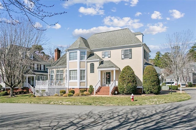 view of front of house with a chimney and a front lawn