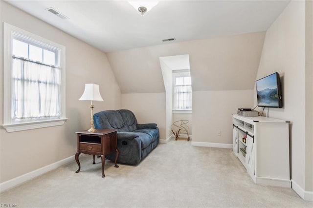 living area featuring light carpet, baseboards, and visible vents