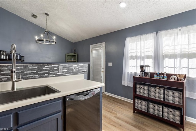 kitchen featuring light countertops, visible vents, vaulted ceiling, light wood-type flooring, and dishwasher