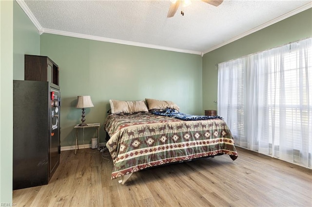 bedroom with freestanding refrigerator, crown molding, a textured ceiling, and wood finished floors