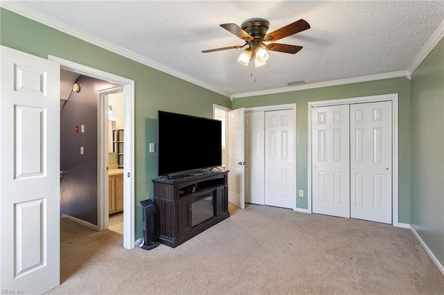 living area featuring a textured ceiling, ornamental molding, carpet, and visible vents