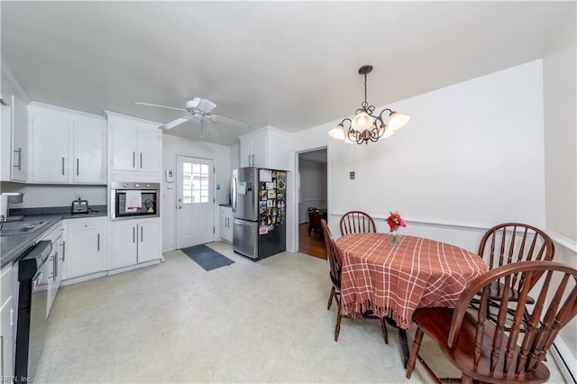 dining room with ceiling fan with notable chandelier and light floors