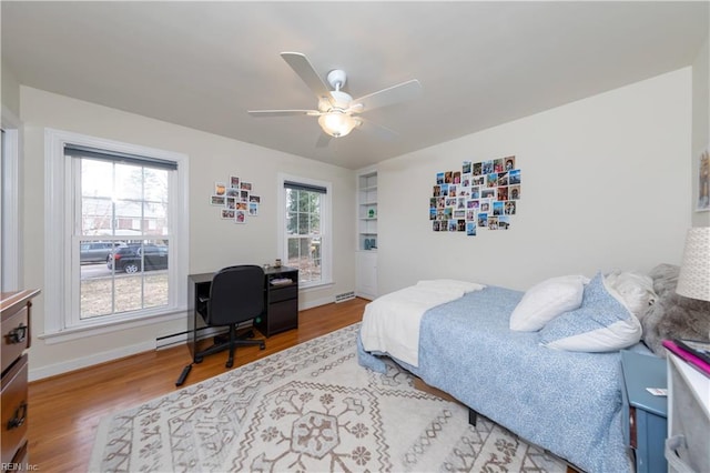 bedroom featuring a ceiling fan, baseboards, and wood finished floors