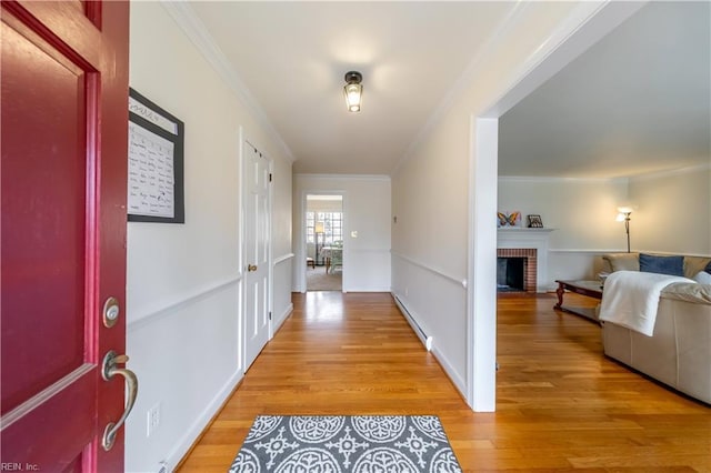 corridor featuring light wood-style flooring and ornamental molding