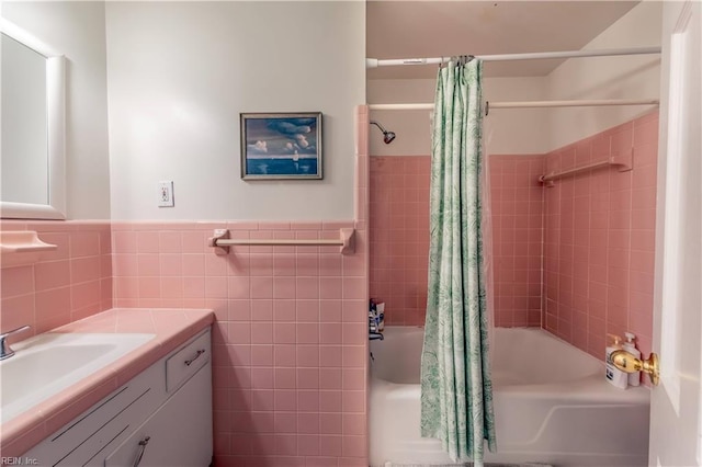 full bathroom featuring wainscoting, shower / bath combination with curtain, tile walls, and vanity