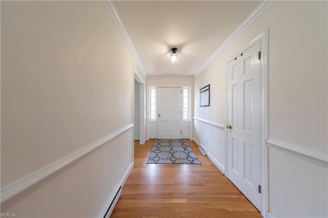 entryway featuring light wood-type flooring, baseboards, ornamental molding, and a baseboard heating unit