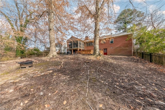 back of house with fence, brick siding, a sunroom, and a chimney