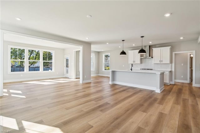 unfurnished living room featuring light wood-type flooring, plenty of natural light, and recessed lighting