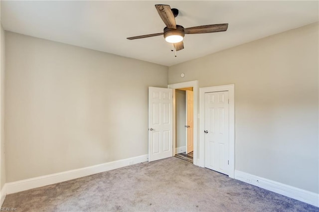 spare room with carpet floors, a ceiling fan, and baseboards