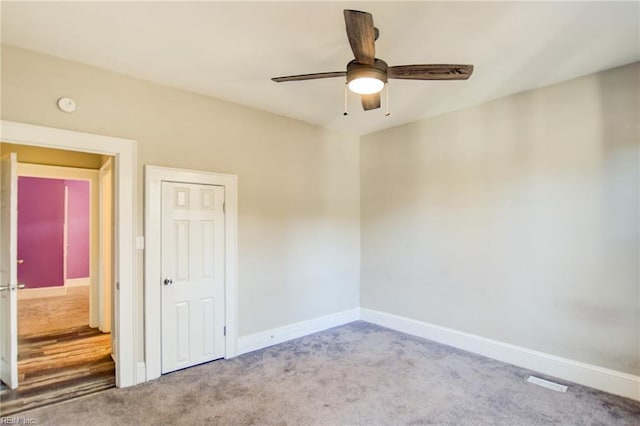 unfurnished room featuring ceiling fan, baseboards, and carpet flooring